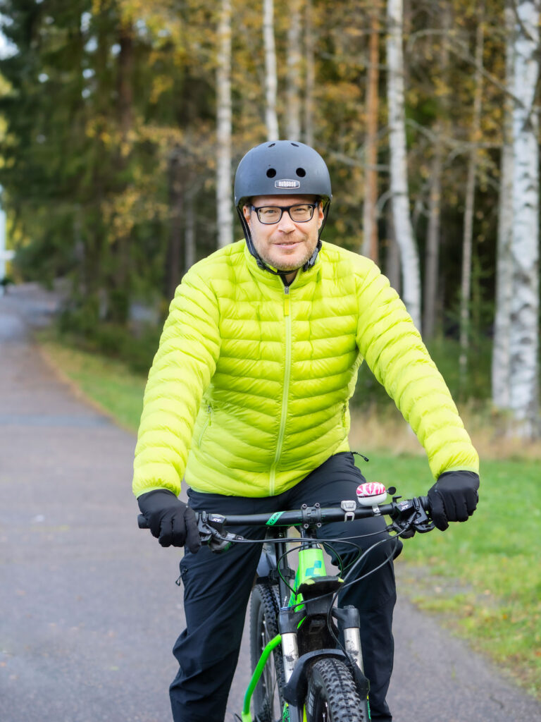 Liikuntalääketieteeseen erikoistuva lääkäri Ari Hännikäinen pyöräilemässä Tampereen urheilulääkäriaseman edustalla.